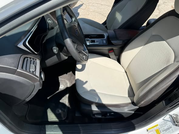 Clean car interior with light upholstery, tidy console and floor mats
